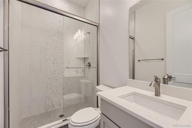 bathroom with toilet, a shower with shower door, and vanity