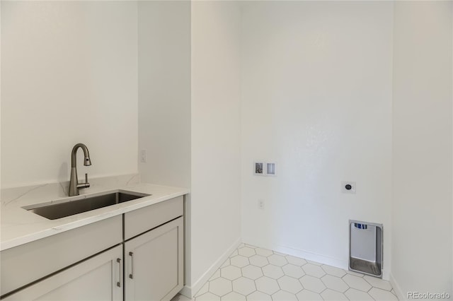 clothes washing area with cabinets, sink, hookup for an electric dryer, light tile patterned flooring, and heating unit