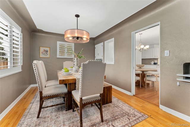 dining space with hardwood / wood-style floors and an inviting chandelier