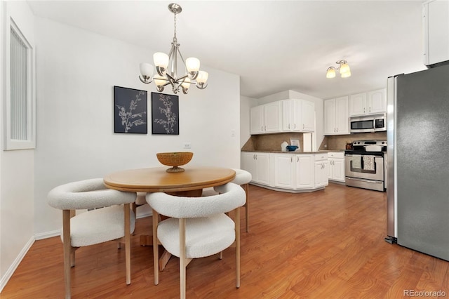 dining room featuring a notable chandelier and light hardwood / wood-style flooring