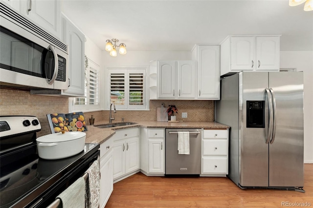 kitchen featuring stainless steel appliances, sink, light hardwood / wood-style flooring, and white cabinetry