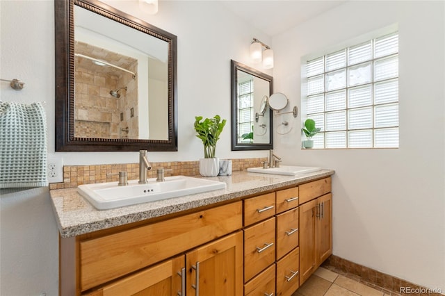 bathroom with tile patterned flooring, backsplash, vanity, and tiled shower