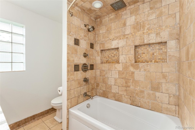 bathroom with tiled shower / bath, tile patterned flooring, and toilet