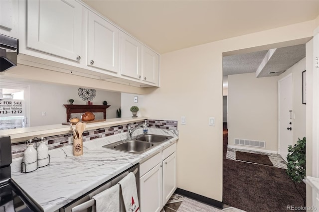 kitchen with sink, a textured ceiling, range, white cabinetry, and light colored carpet