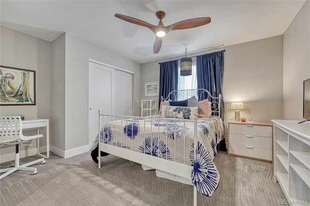 bedroom featuring baseboards, a ceiling fan, a closet, and light colored carpet