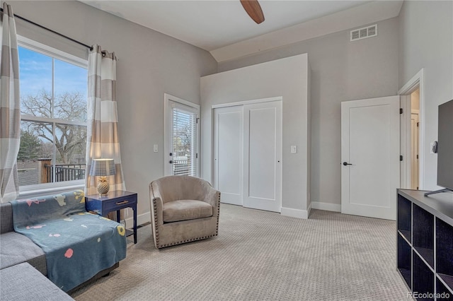 living area with carpet floors, a ceiling fan, baseboards, and visible vents