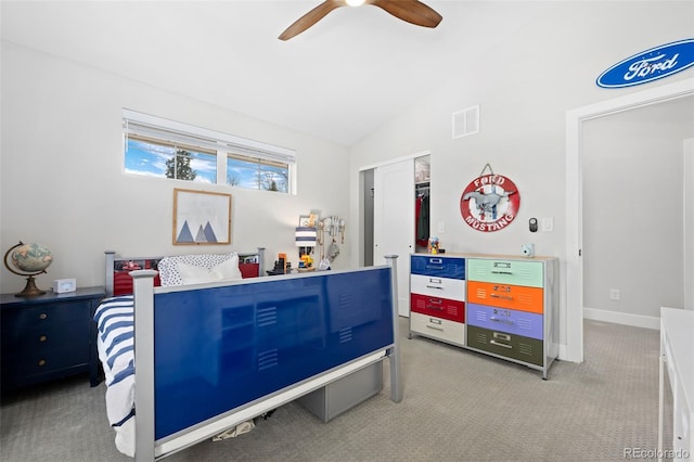carpeted bedroom featuring visible vents, ceiling fan, vaulted ceiling, and a closet
