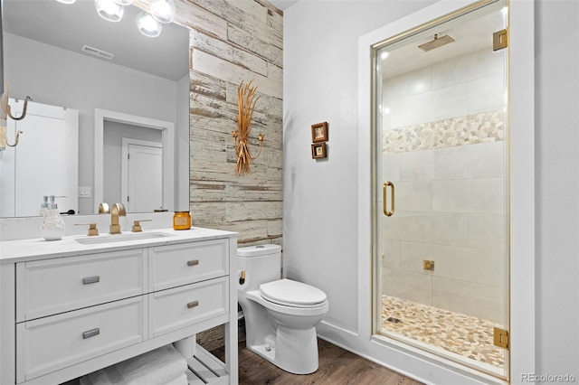 bathroom with visible vents, a stall shower, wood finished floors, vanity, and toilet