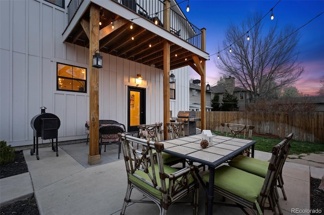 view of patio / terrace featuring fence, a balcony, area for grilling, and outdoor dining space