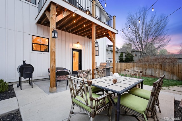 2948 S Clarkson St, Englewood, CO 80113 - patio terrace at dusk with outdoor dining space, fence, a balcony, and grilling area