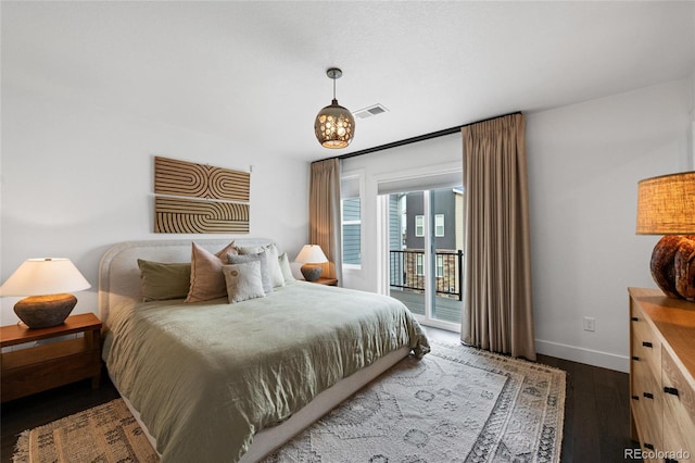 bedroom featuring access to exterior and dark hardwood / wood-style floors