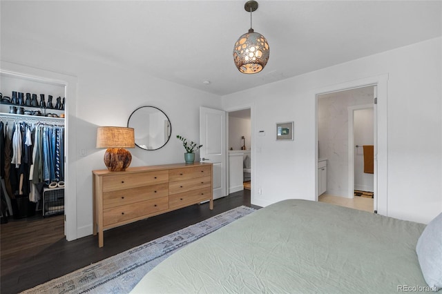 bedroom featuring ensuite bathroom, a closet, and dark hardwood / wood-style floors