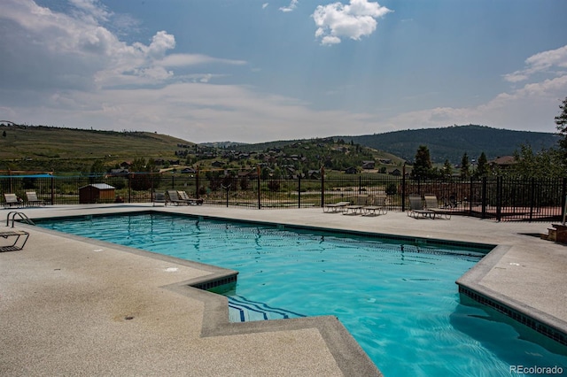 view of pool with a mountain view and a patio area