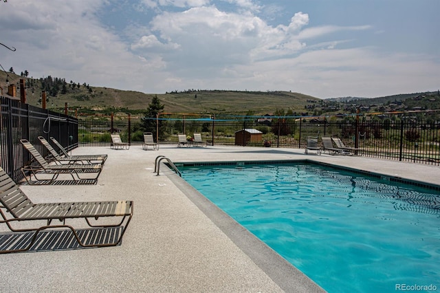 view of pool featuring a mountain view and a patio area