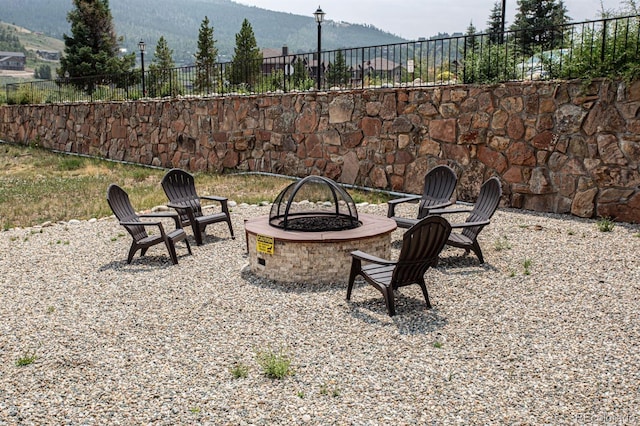 view of patio / terrace featuring an outdoor fire pit and a mountain view