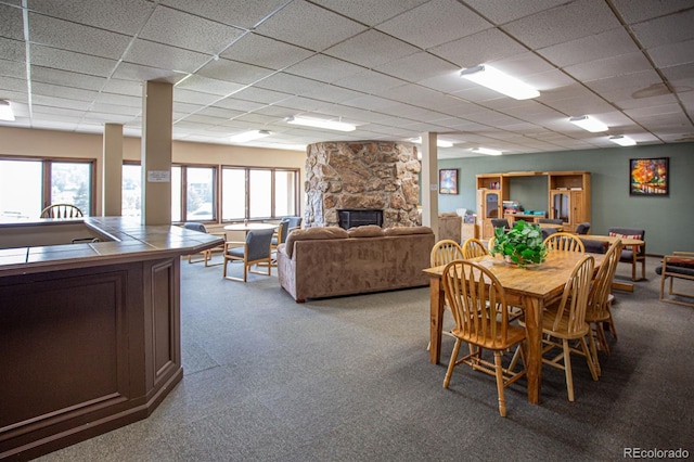 dining space with a paneled ceiling and a fireplace