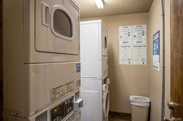 clothes washing area featuring stacked washer and clothes dryer and a textured ceiling