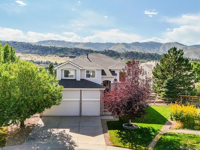 view of front property featuring a mountain view, a front lawn, and a garage