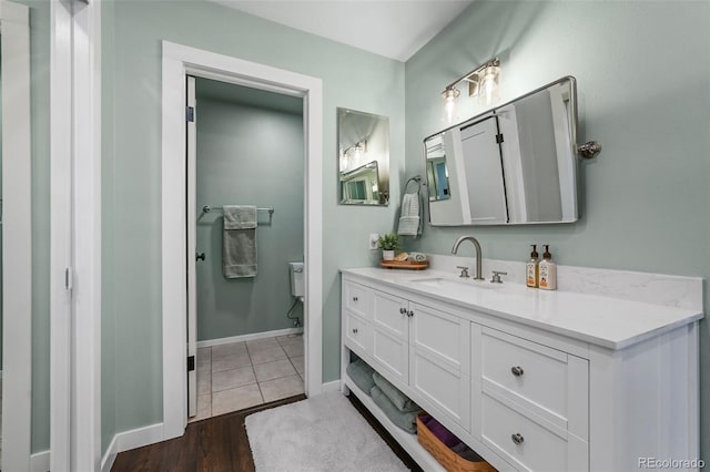 10743 W Turtle Mtn, Littleton, CO 80127 - bathroom featuring toilet, vanity, baseboards, and wood finished floors