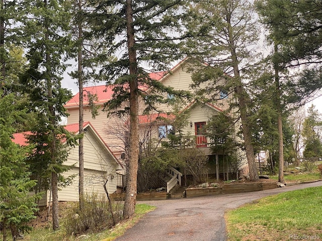 view of front of home with stairs and aphalt driveway