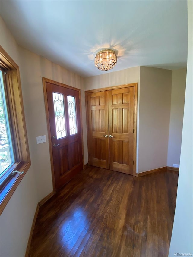 entryway featuring baseboards and dark wood finished floors