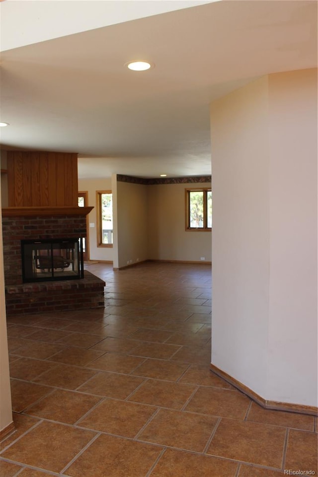 unfurnished living room featuring recessed lighting, baseboards, and a fireplace
