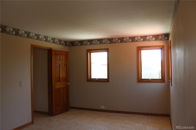 spare room with baseboards and a healthy amount of sunlight