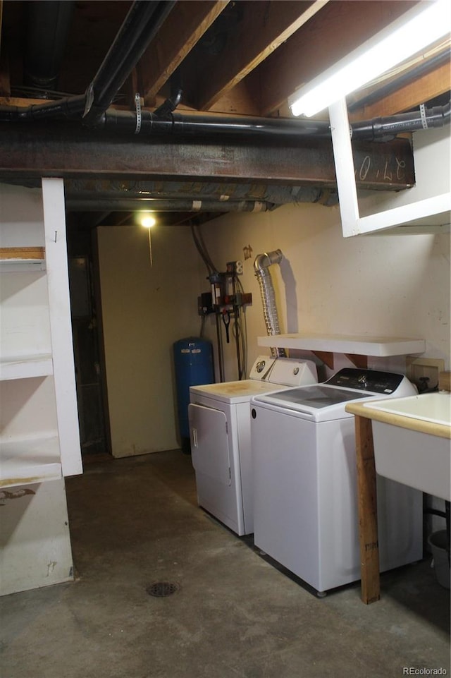 laundry area with laundry area, a sink, and washing machine and clothes dryer