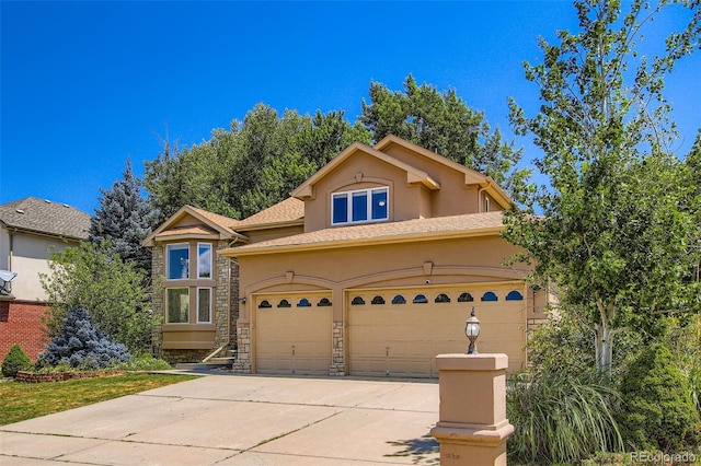 7482 Routt Ln, Arvada, CO 80005 - view of front of house with stucco siding, stone siding, a garage, and driveway