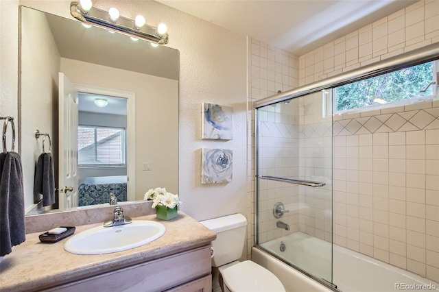7482 Routt Ln, Arvada, CO 80005 - ensuite bathroom with plenty of natural light, vanity, shower / bath combination with glass door, and a textured wall