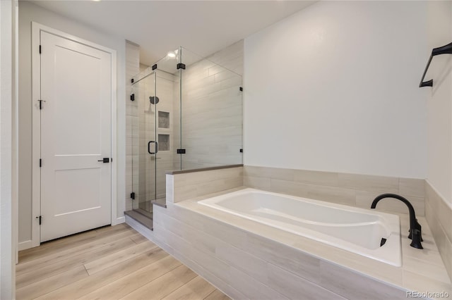 bathroom with hardwood / wood-style flooring and separate shower and tub