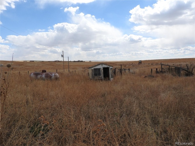 view of yard featuring a rural view and an outdoor structure