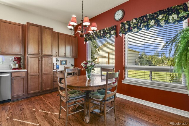 dining area featuring dark wood-type flooring, baseboards, plenty of natural light, and a chandelier