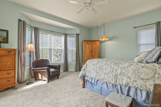 carpeted bedroom featuring baseboards and a ceiling fan