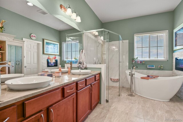 full bath with a sink, plenty of natural light, a stall shower, and double vanity