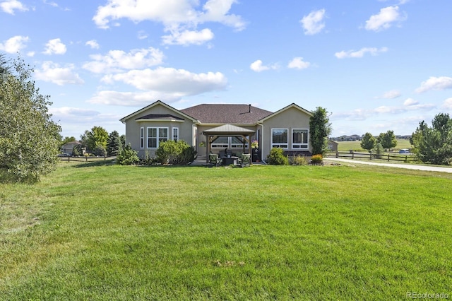 single story home featuring stucco siding, a gazebo, fence, and a front lawn