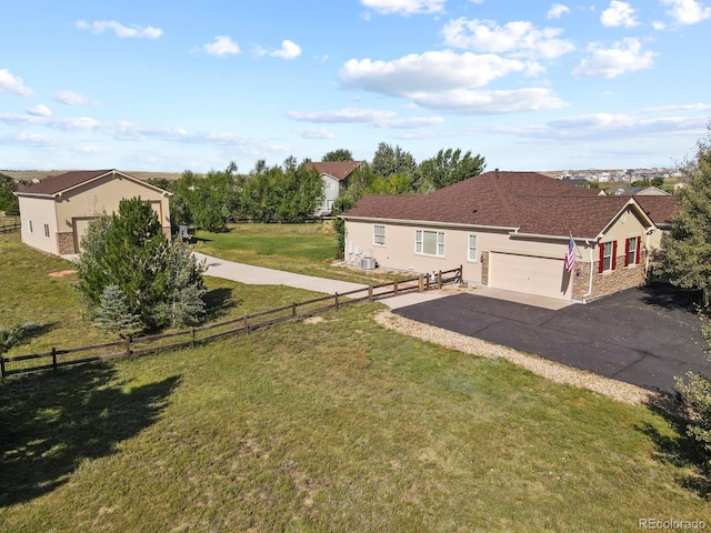 exterior space featuring a garage, a front lawn, stucco siding, and fence