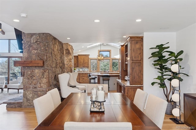 dining space featuring vaulted ceiling and light wood-type flooring