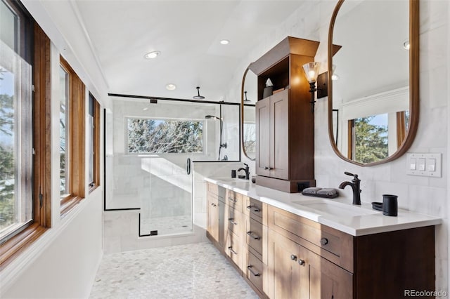 bathroom with vanity, a wealth of natural light, a shower with shower door, and tile walls