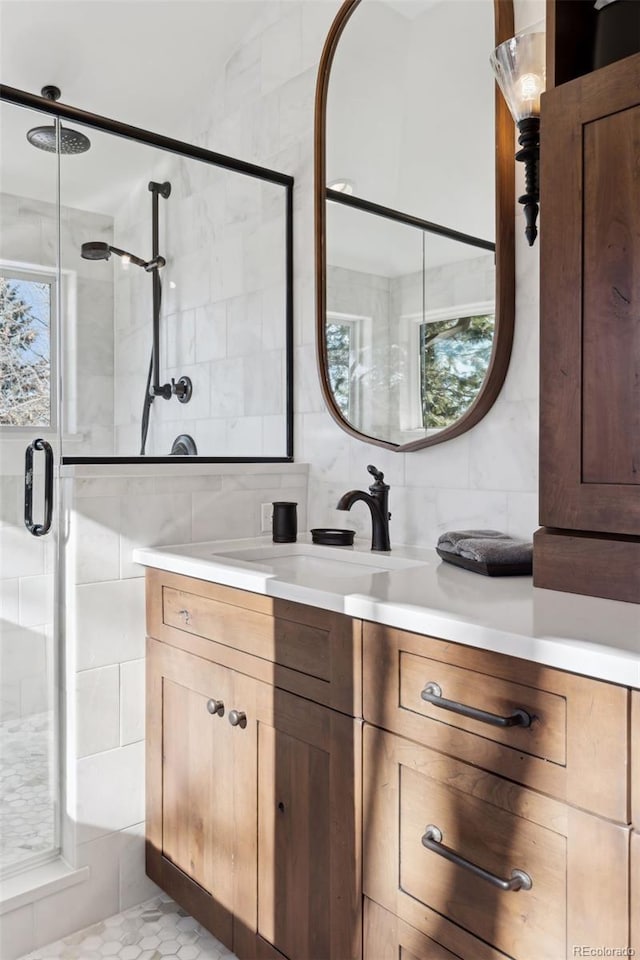 bathroom featuring tile walls, vanity, backsplash, and an enclosed shower