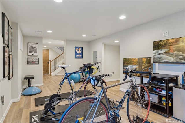 exercise room featuring light hardwood / wood-style flooring and electric panel