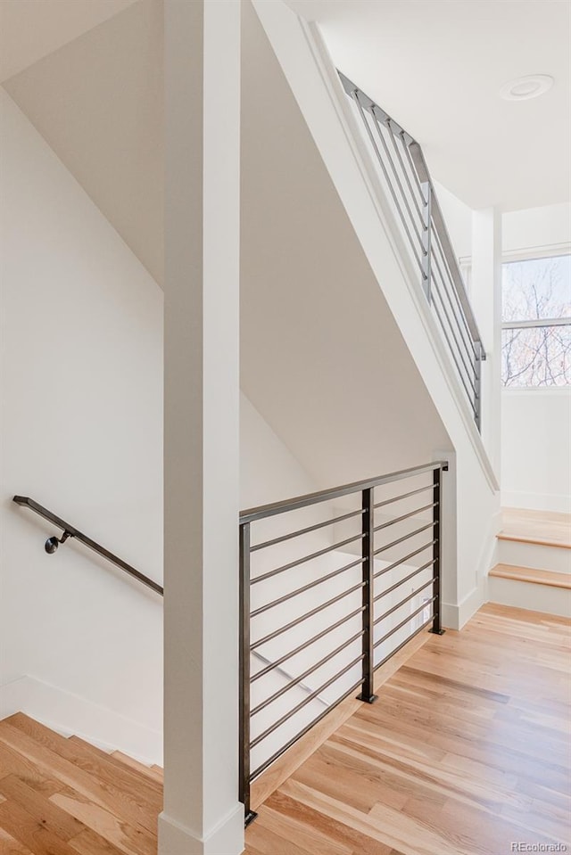 stairway with wood finished floors and baseboards