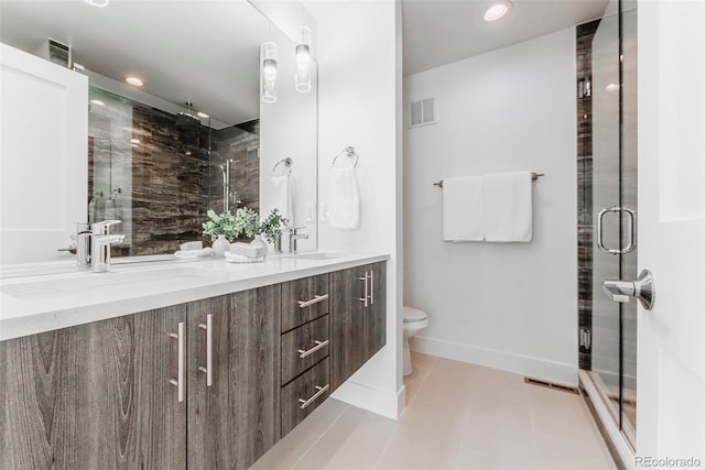 bathroom with a stall shower, a sink, and double vanity