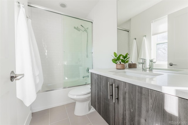 bathroom featuring bath / shower combo with glass door, vanity, toilet, and tile patterned floors