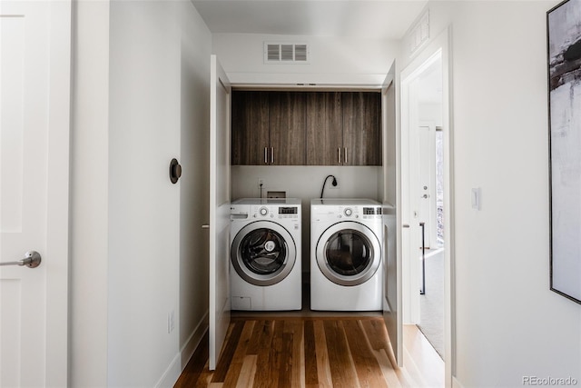 laundry room featuring laundry area, visible vents, wood finished floors, and independent washer and dryer