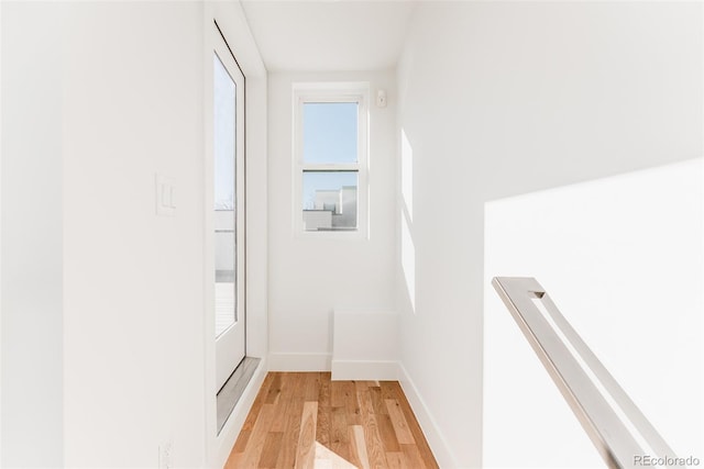 hallway with light wood-style floors and baseboards