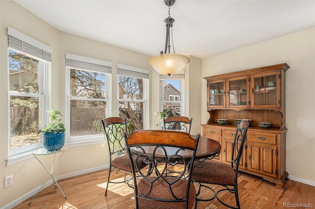 dining area featuring baseboards, plenty of natural light, and light wood-style flooring