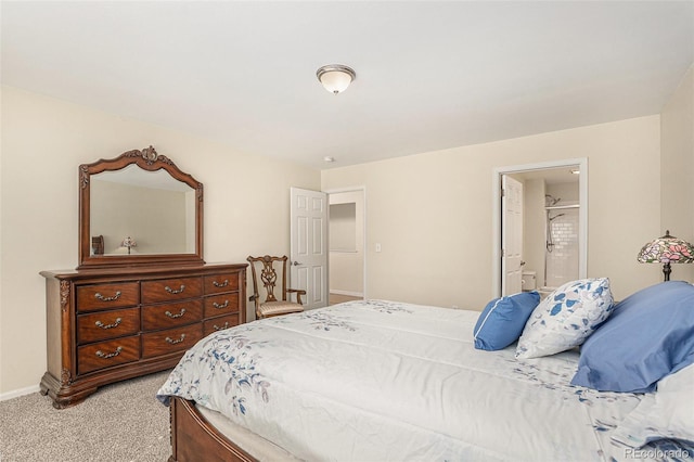 bedroom with light colored carpet, baseboards, and connected bathroom