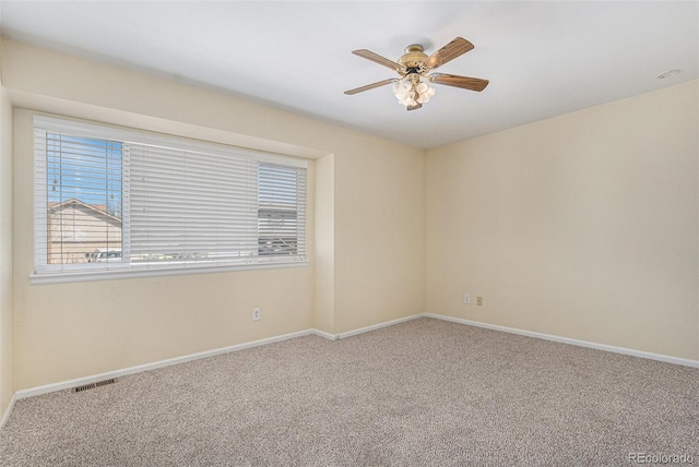 empty room with visible vents, ceiling fan, baseboards, and carpet