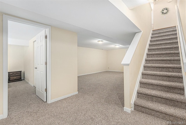 staircase featuring baseboards and carpet floors